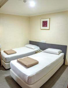 a room with three beds in a room at Amrise Hotel, Check in at 10PM, Check out at 9AM in Singapore