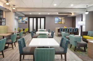a waiting room with tables and chairs at Hampton Inn - Greenville in Greenville