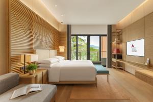 a hotel room with a bed and a couch at Shenzhen Marriott Hotel Golden Bay in Shenzhen