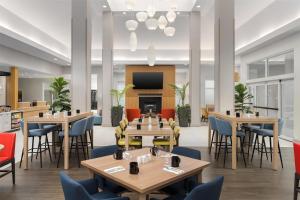 a restaurant with tables and chairs and a flat screen tv at Hilton Garden Inn Dover in Dover