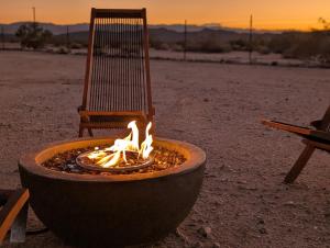 a fire pit with a chair sitting next to a chair at Golden Moon Hideaway in Twentynine Palms +12 photos