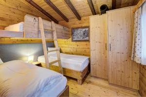 a bedroom with two bunk beds and a ladder at Ferienhaus Gasteg in Maria Alm am Steinernen Meer