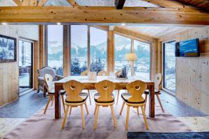 a dining room with a large wooden table and chairs at Ferienhaus Gasteg in Maria Alm am Steinernen Meer +14 photos