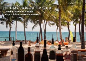 a group of bottles on a beach with palm trees at The St. Regis Sanya Yalong Bay Resort in Sanya