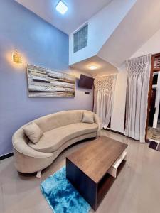 a living room with a couch and a coffee table at Serandib Town Apartment in Weligama