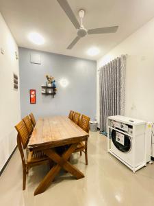 a dining room with a table and a microwave at Serandib Town Apartment in Weligama