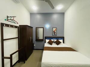 a bedroom with two beds and a mirror at Serandib Town Apartment in Weligama