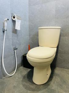 a bathroom with a toilet and a roll of toilet paper at Serandib Town Apartment in Weligama