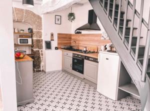 a kitchen with white cabinets and a staircase at Le coin des Samariens - Étape Saint-Jacques in Golinhac