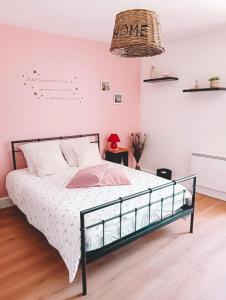 a bedroom with a bed in a room with pink walls at Le coin des Samariens - Étape Saint-Jacques in Golinhac