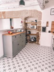 a kitchen with a counter and a tile floor at Le coin des Samariens - Étape Saint-Jacques in Golinhac