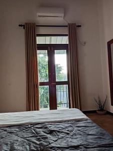 a bedroom with a bed and a large window at Villa Nuelumalee UpStairs in Hikkaduwa +33 photos