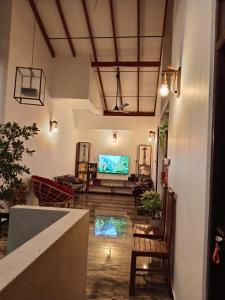 a living room with a large screen tv in a room at Villa Nuelumalee UpStairs in Hikkaduwa