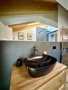 a large black tub sitting on top of a wooden counter in a bathroom at Mulini 22 - Eco Suite & Spa in Temù +255 photos