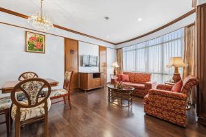 a living room with a couch and a table at Town in Town Hotel Bangkok in Bangkok