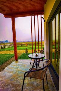 a patio with a table and chairs on a porch at F A N BunGALow Vama Buzăului in Vama Buzăului