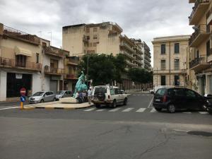 uma rua da cidade com carros e uma estátua no meio em Hotel Europa em Vittoria
