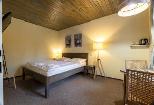 a bedroom with a bed and a wooden ceiling at Penzion Rodos - Café in Prague
