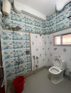 a bathroom with a toilet and a shower at Narasimha Dev Guest House in mayapur