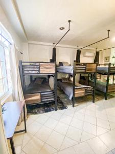 a room with three bunk beds and a mirror at Baja Cabo Hostal Arenal in Cabo San Lucas