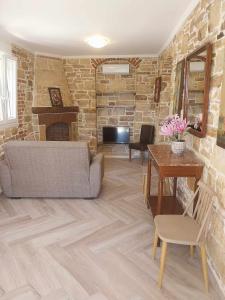 a living room with a couch and a stone wall at Villa Kalliope in Nénita