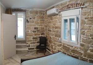 a room with a stone wall and a black chair at Villa Kalliope in Nénita