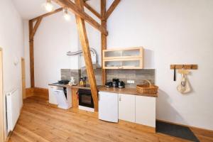 a kitchen with white cabinets and a wooden floor at Spreewald Spreemilia Gurkenbude in Lübbenau