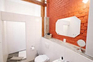 a bathroom with a white toilet and a brick wall at Spreewald Spreemilia Gurkenbude in Lübbenau +18 photos