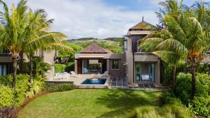 an aerial view of a house with a pool and palm trees at Heritage The Villas in Bel Ombre