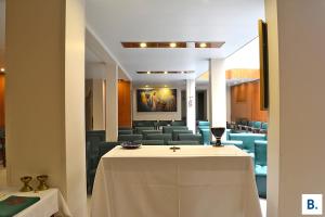a conference room with a white table and chairs at Hôtel Croix des Bretons - Lourdes Pyrénées in Lourdes