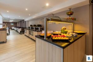 a buffet in a hotel room with food on a counter at Hôtel Croix des Bretons - Lourdes Pyrénées in Lourdes