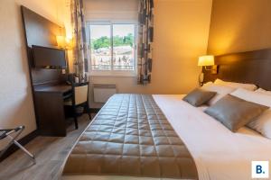 a hotel room with a bed and a desk and a window at Hôtel Croix des Bretons - Lourdes Pyrénées in Lourdes +83 photos
