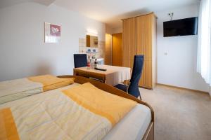 a hotel room with two beds and a table and a television at Gasthaus Krone in Pforzheim +15 photos