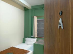 a room with a green wall and a door with a alphabet at MANITA Banyainim in Krabi