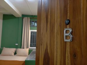 a wooden door with a bed in a room at MANITA Banyainim in Krabi