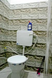 a white toilet in a bathroom with a wall at Dh Hotel in Bhiwāni +18 photos