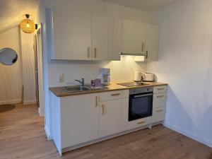 a kitchen with white cabinets and a sink at Nordhavn in Harrislee