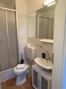 a white bathroom with a toilet and a sink at Nordhavn in Harrislee