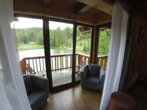 a room with a balcony with a view of a lake at Hotel Ozero Vita in Nizhniy Studenyy