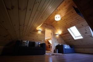 a living room with two couches in a attic at Hotel Ozero Vita in Nizhniy Studenyy