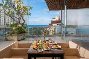 a table with plates of food on top of a building at Avatar Danang Hotel in Danang