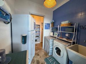 a kitchen with a refrigerator and a washing machine at Sicily Sea Villa Capo Zafferano in Santa Flavia