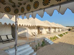 a row of tents with chairs and tables at Gj02 desert resort in Jaisalmer