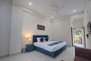 a bedroom with a large bed and a window at Forest Nest Farm Stay in Rājpur