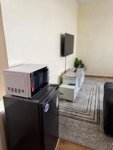 a microwave sitting on top of a refrigerator in a room at TMT Homes in Nairobi