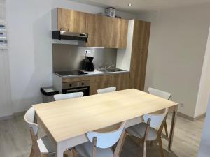 a kitchen with a wooden table and chairs at Signature Apartment in Pélussin