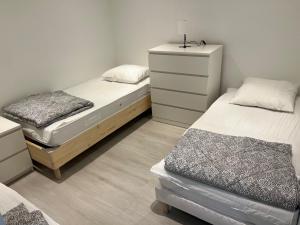 a bedroom with two beds and a dresser at Signature Apartment in Pélussin