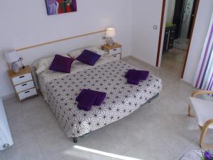 Un dormitorio con una cama con almohadas moradas. en La Casa del Centre, en Tàrrega