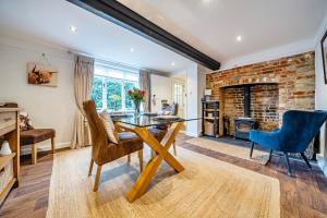 a dining room with a table and chairs and a fireplace at Old Rectory Cottage, Tostock in Tostock