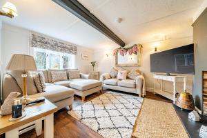a living room with two couches and a flat screen tv at Old Rectory Cottage, Tostock in Tostock
